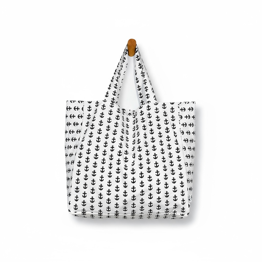 Tote bag with black anchor pattern hanging on a white background